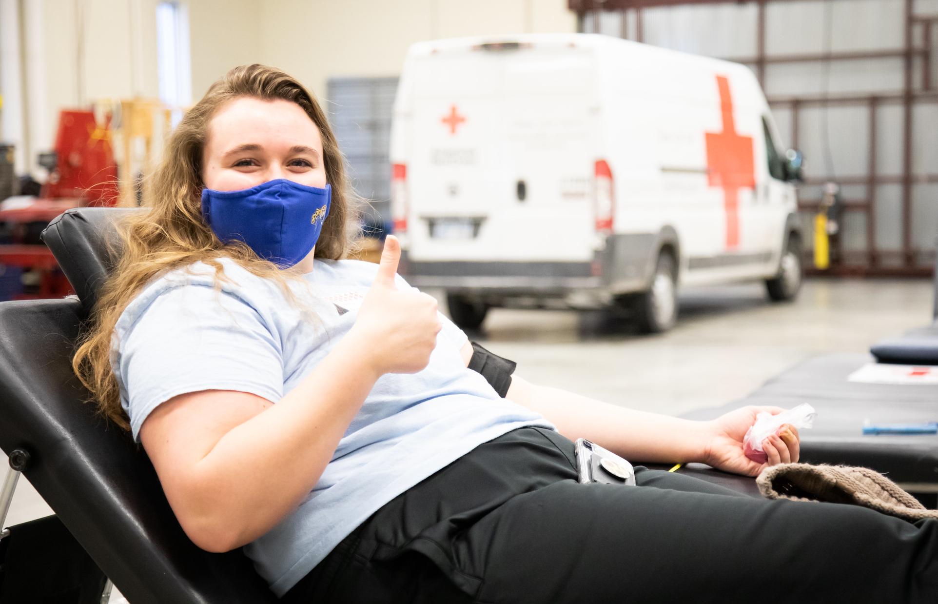 person giving thumbs up giving blood