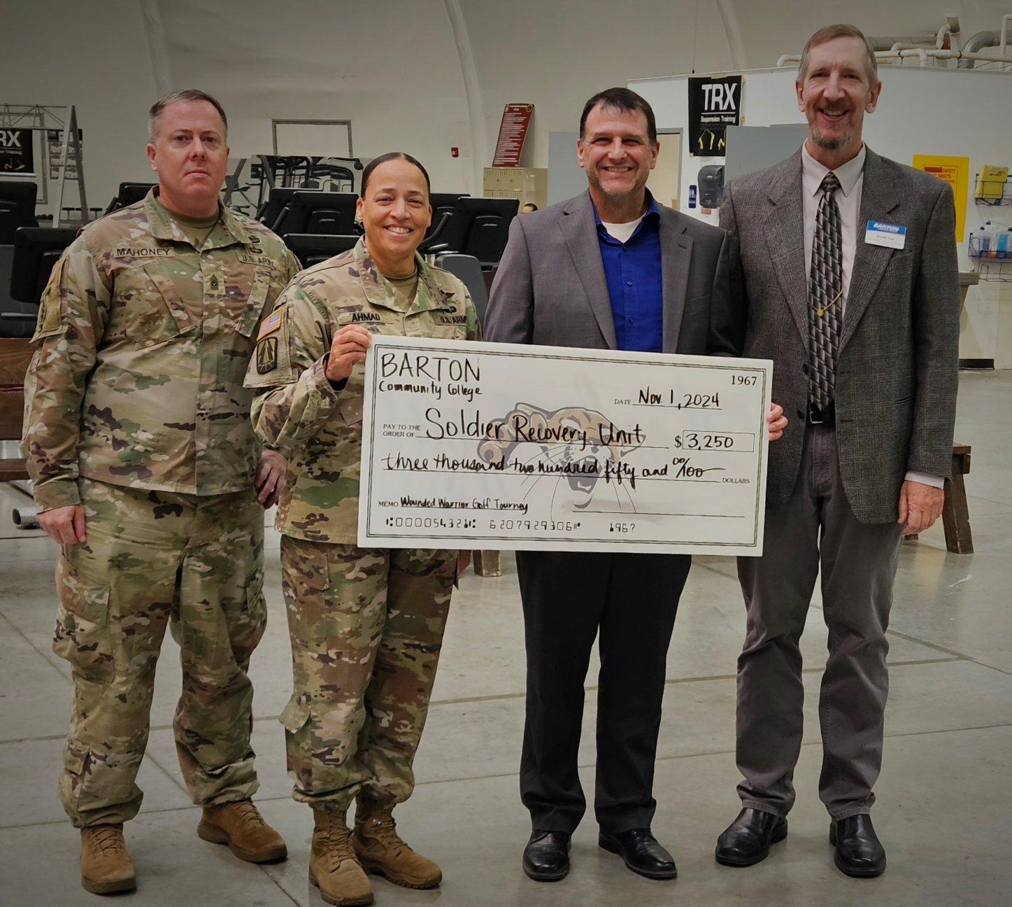 Barton Dean of Military Academics, Technical Education and Outreach Programs Kurt Teal and Barton President Dr. Marcus Garstecki present a check from proceeds of the annual Wounded Warrior Golf Scramble for $3,250 to Fort Riley Soldier Recovery Unit Leadership, Lieutenant Colonel Yolanda Ahmad and Command Sergeant Major Joseph Mahoney.